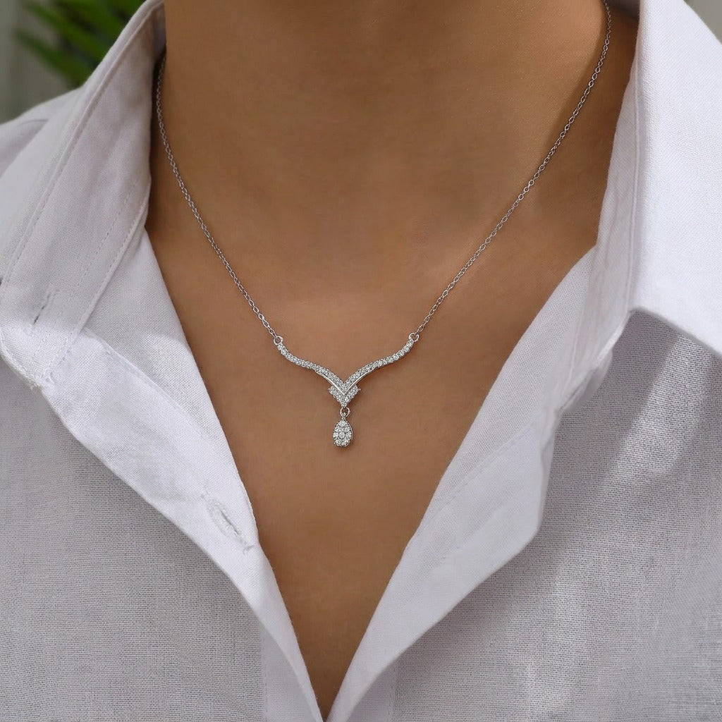 Inspired by the crisp, sparkling beauty of high-mountain peaks, the Alpine Drop Necklace is a masterclass in understated luxury. This piece features a graceful, V-shaped "Alpine" silhouette that leads the eye to a brilliant teardrop focal point, creating an elegant lengthening effect that elevates any neckline.