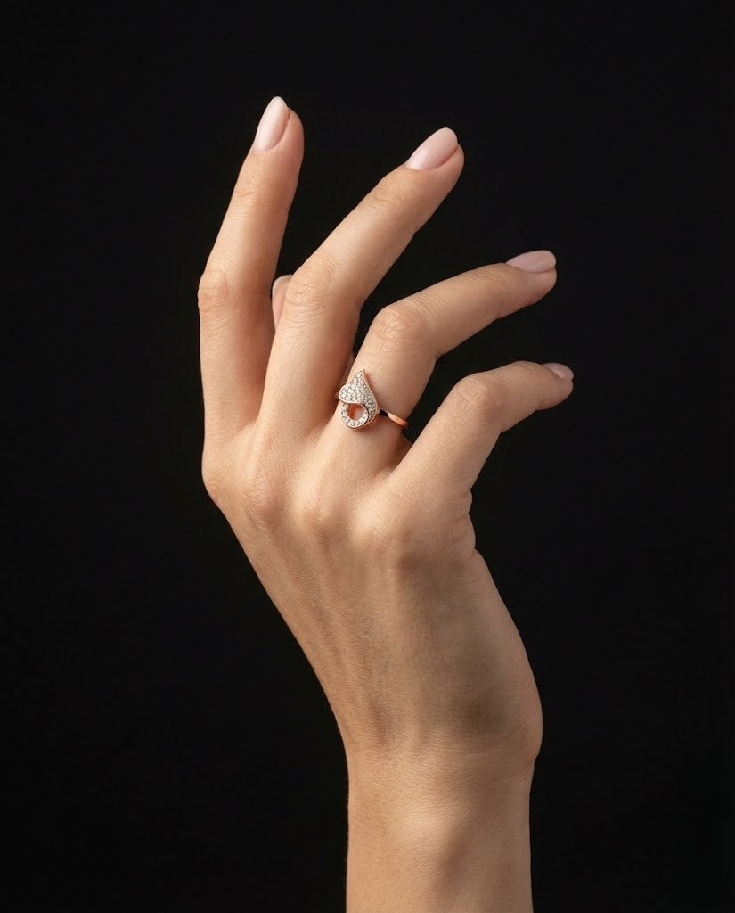 A romantic statement ring defined by a fluid heart-inspired silhouette and a soft cascade of shimmering zircon stones. The Amoria Flow Ring is designed to symbolize effortless love and graceful movement—where curves meet sparkle in perfect harmony. Elegant yet expressive, it adds warmth and charm to every gesture.