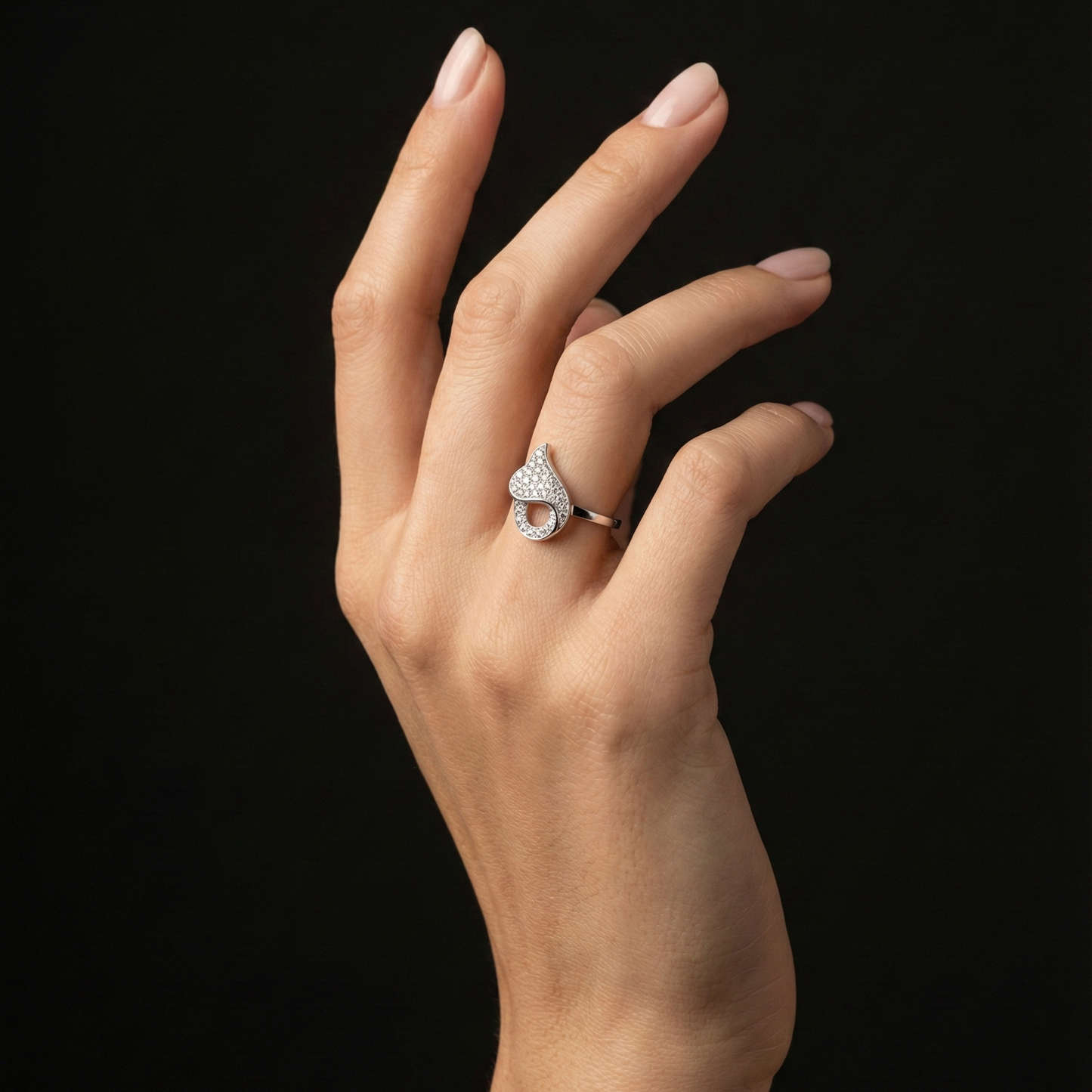 A romantic statement ring defined by a fluid heart-inspired silhouette and a soft cascade of shimmering zircon stones. The Amoria Flow Ring is designed to symbolize effortless love and graceful movement—where curves meet sparkle in perfect harmony. Elegant yet expressive, it adds warmth and charm to every gesture.
