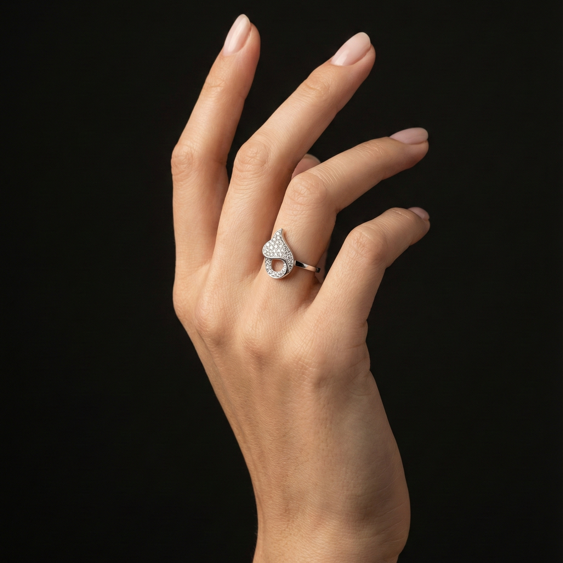 A romantic statement ring defined by a fluid heart-inspired silhouette and a soft cascade of shimmering zircon stones. The Amoria Flow Ring is designed to symbolize effortless love and graceful movement—where curves meet sparkle in perfect harmony. Elegant yet expressive, it adds warmth and charm to every gesture.