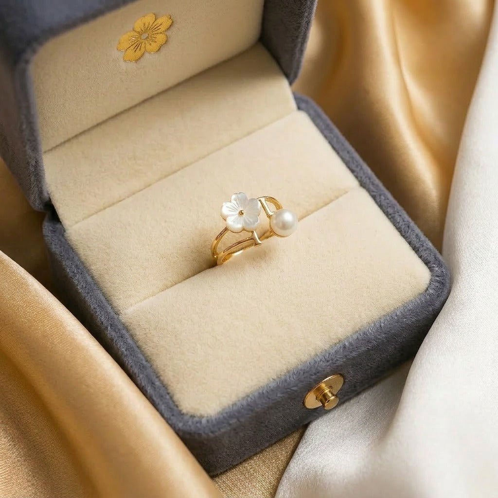 A delicate bloom touched with pearl elegance, this ring features a soft floral centerpiece paired with a luminous pearl accent in an airy open silhouette. Its minimal floral charm creates a graceful statement that feels feminine, fresh, and timeless.
