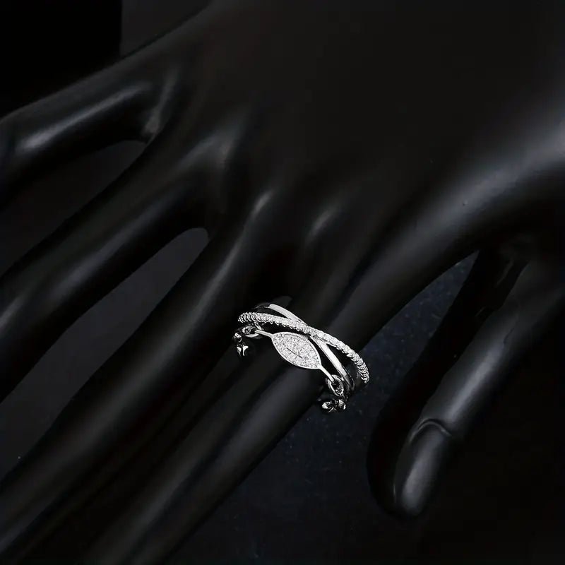 The Lustre Loop Ring features a beautifully intertwined design that blends modern elegance with delicate brilliance. Accented with shimmering zircon stones and a sleek looped structure, this ring creates a flowing silhouette that feels both refined and eye-catching. The unique loop design symbolizes continuity and elegance. Available exclusively at Loftique your One Stop Gifting Solution.