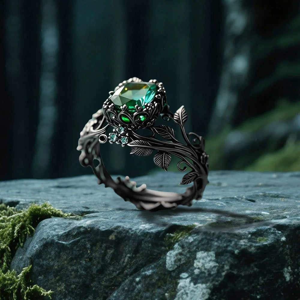 The Midnight Ivy Ring is a lush creation rooted in gothic romance and dark enchantment. A deep green crystal glows at the center, crowned by intricate vines and leaf motifs that wrap the finger like a secret from an ancient forest. Gunmetal tones and shimmering side zircons bring drama, elegance, and a mythical edge to this bold statement piece.