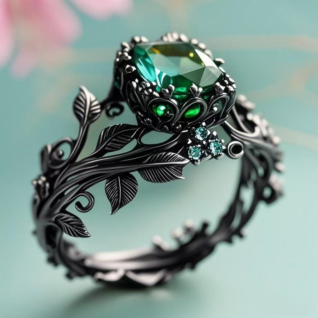 The Midnight Ivy Ring is a lush creation rooted in gothic romance and dark enchantment. A deep green crystal glows at the center, crowned by intricate vines and leaf motifs that wrap the finger like a secret from an ancient forest. Gunmetal tones and shimmering side zircons bring drama, elegance, and a mythical edge to this bold statement piece.