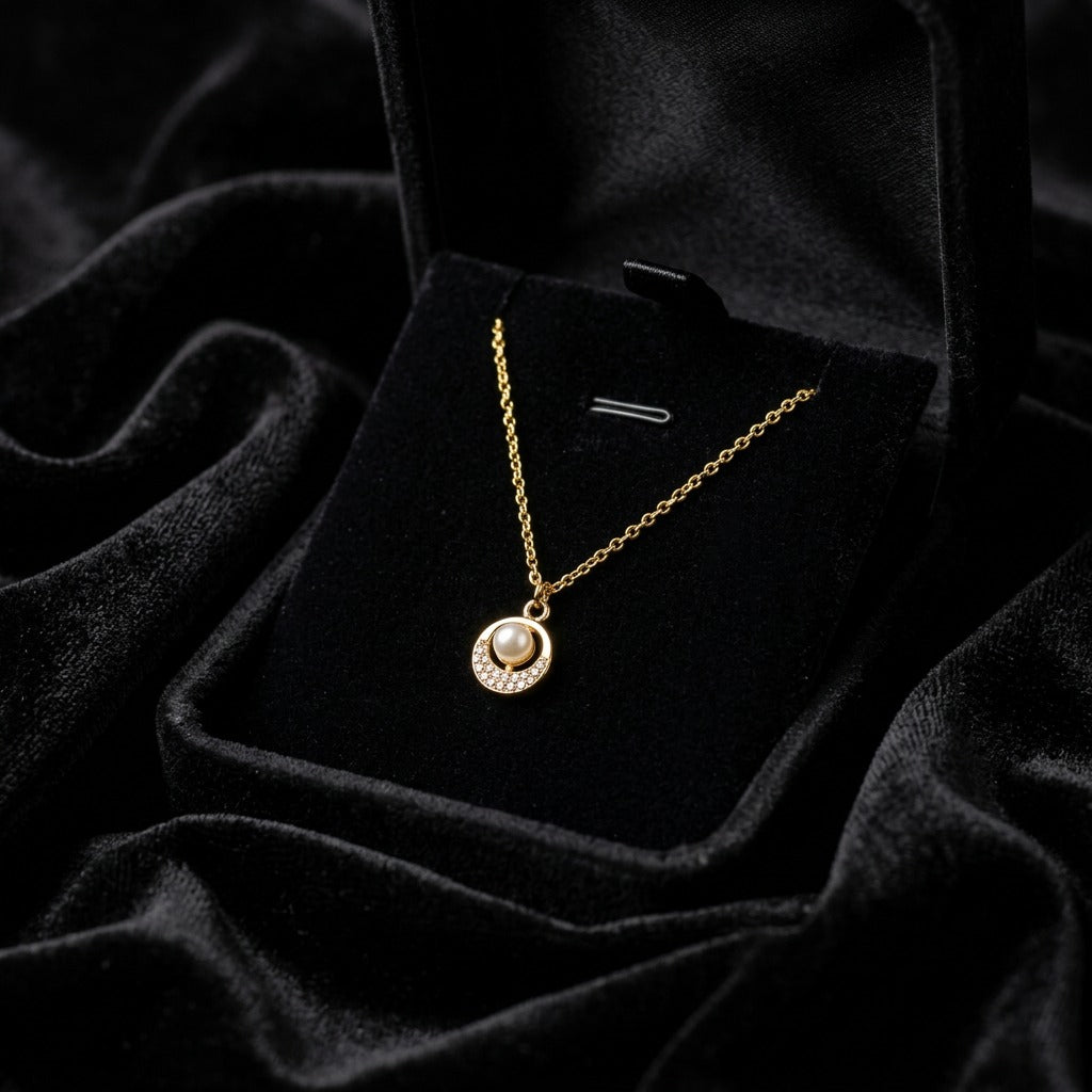 A soft pearl glow framed with delicate crystal sparkle, this necklace captures a timeless elegance in the most minimal way. Its refined circular pendant and sleek silver finish create a graceful everyday piece that feels effortlessly luxurious.