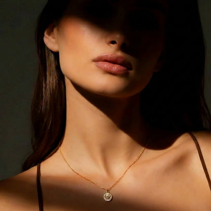 A soft pearl glow framed with delicate crystal sparkle, this necklace captures a timeless elegance in the most minimal way. Its refined circular pendant and sleek silver finish create a graceful everyday piece that feels effortlessly luxurious.