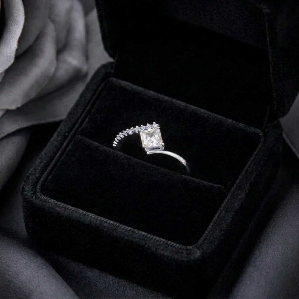 A radiant statement of clean elegance, this ring captures the beauty of modern minimalism with its striking square-cut centerpiece and refined silhouette. The brilliant stone catches light effortlessly, creating a timeless sparkle that feels both luxurious and graceful.