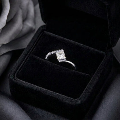 A radiant statement of clean elegance, this ring captures the beauty of modern minimalism with its striking square-cut centerpiece and refined silhouette. The brilliant stone catches light effortlessly, creating a timeless sparkle that feels both luxurious and graceful.