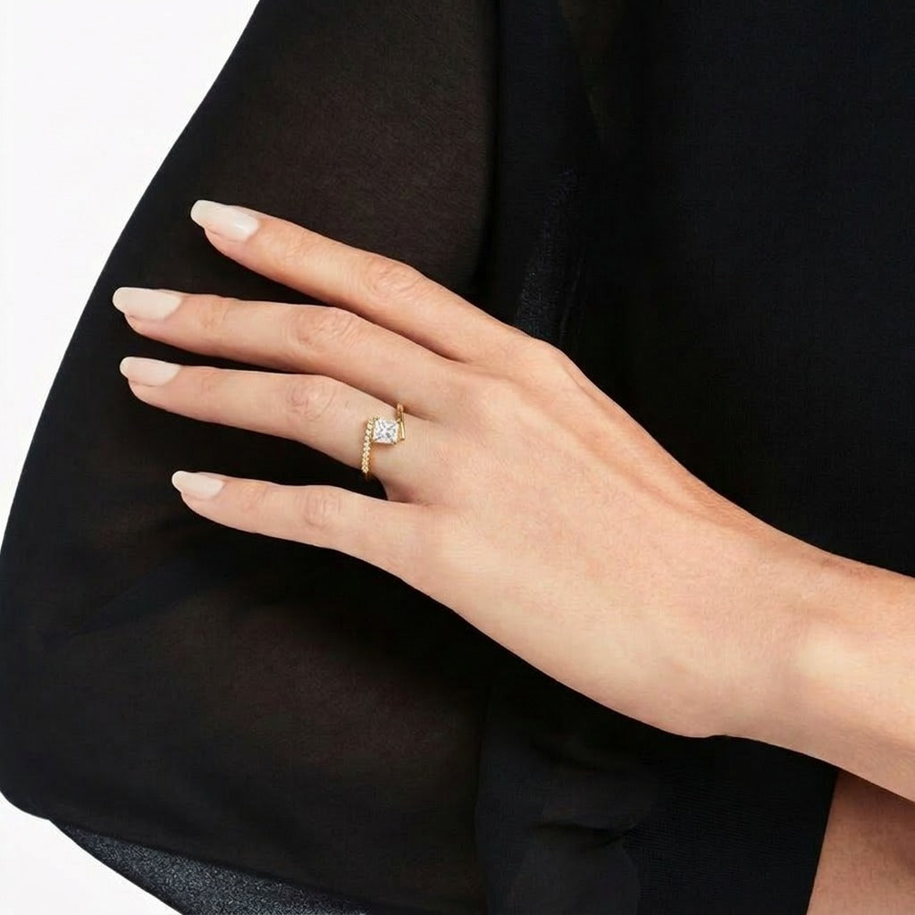A radiant statement of clean elegance, this ring captures the beauty of modern minimalism with its striking square-cut centerpiece and refined silhouette. The brilliant stone catches light effortlessly, creating a timeless sparkle that feels both luxurious and graceful.