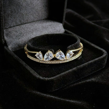 A sleek brilliance that flows with effortless grace, this bracelet captures the beauty of cascading light in a refined, modern form. The line of shimmering crystals paired with delicate drop accents creates a soft, radiant movement that feels both luxurious and timeless.