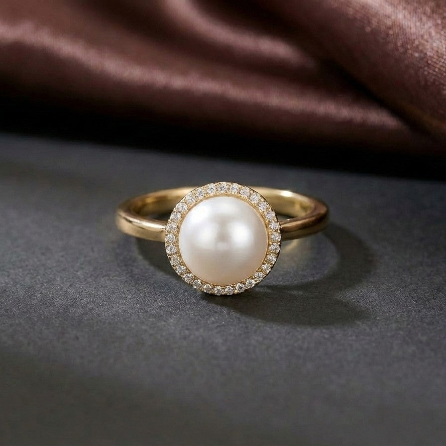 A timeless symbol of elegance, the Pearl Crown Ring brings together the softness of a luminous pearl and the brilliance of a delicate halo. Framed like a crown, its radiant design adds a graceful glow to every gesture.