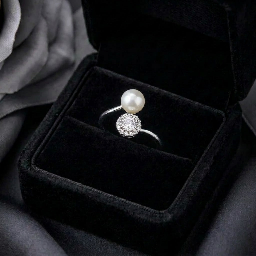 A graceful balance of luminous elegance and sparkling brilliance, this ring features a floating pearl paired with a radiant crystal cluster in a modern open silhouette. Its celestial-inspired design creates a soft statement that feels refined, timeless, and effortlessly elegant.