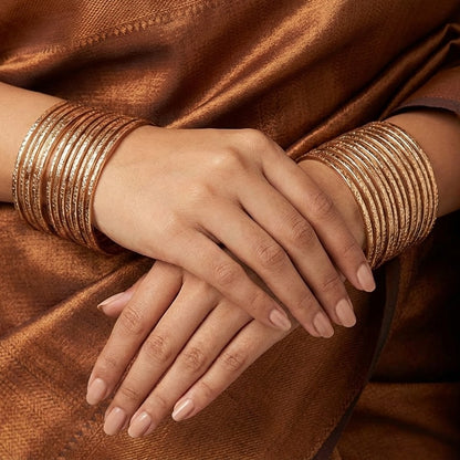 A soft cascade of textured shine, the Raindrop Kangan captures the delicate rhythm of falling droplets in every curve. Each bangle reflects light with a subtle shimmer, creating a fluid, layered look that feels both graceful and bold at once.