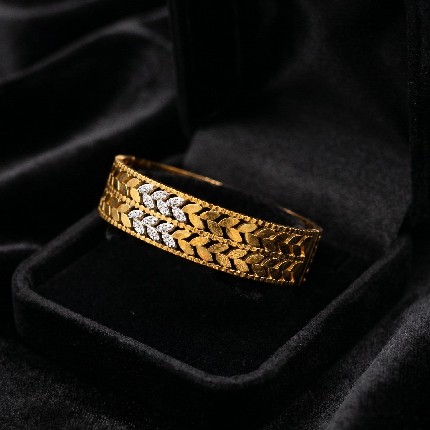 A timeless blend of heritage elegance and refined artistry, this bangle captures the beauty of woven leaf motifs in a rich golden silhouette. The alternating polished details and sparkling accents create a regal look that feels both traditional and luxurious.