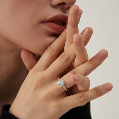 A timeless bloom of brilliance, this ring features a radiant center stone embraced by a shimmering halo that reflects light beautifully from every angle. Its classic silhouette and delicate sparkle create an elegant charm that feels refined, romantic, and everlasting.