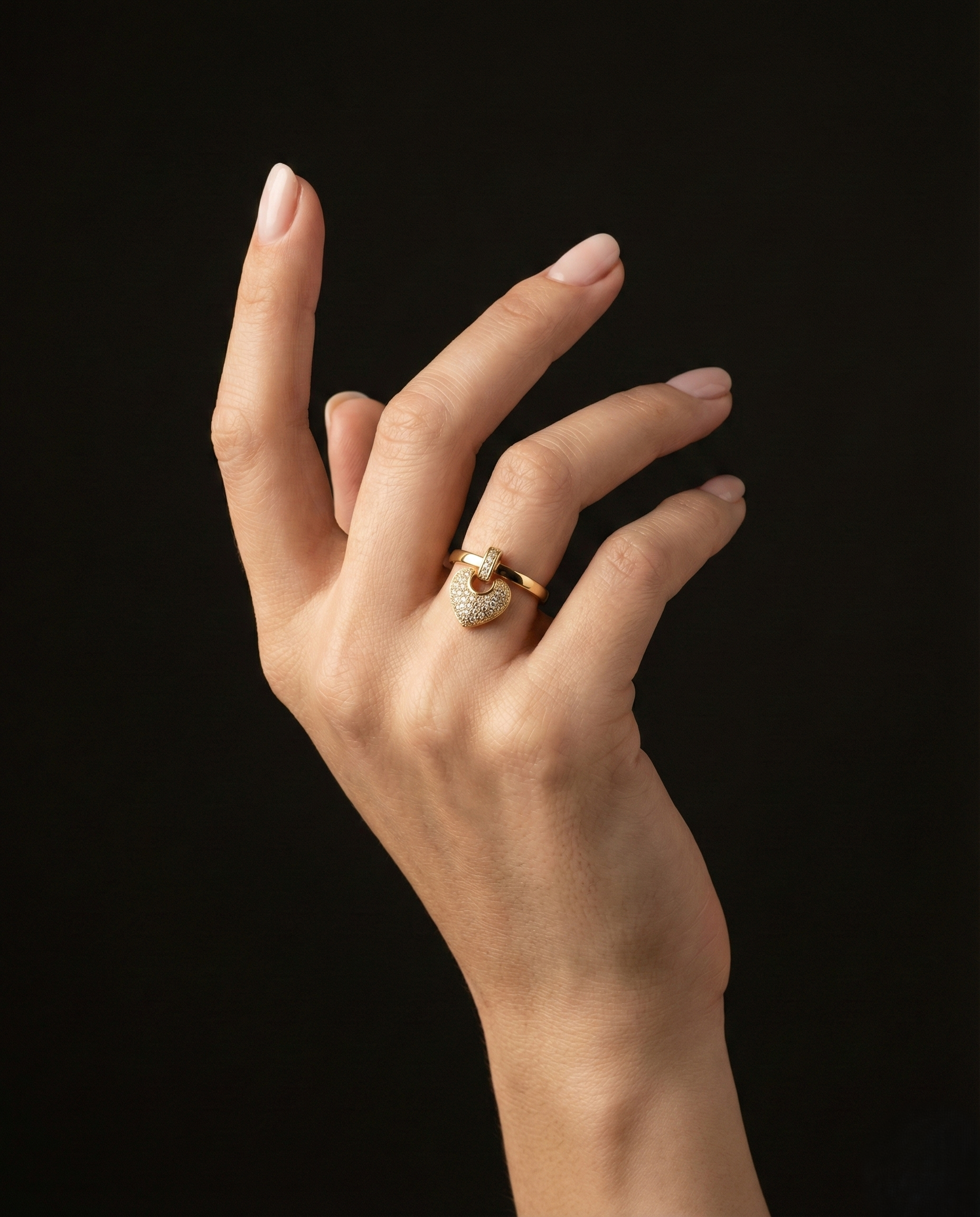 A romantic statement ring defined by a delicate hanging heart silhouette, softly paved with shimmering zircon stones. The Velmora Heart Ring is designed to capture love in motion graceful, expressive, and full of feeling. Its suspended heart detail adds gentle movement, making the design feel alive, emotional, and irresistibly charming.