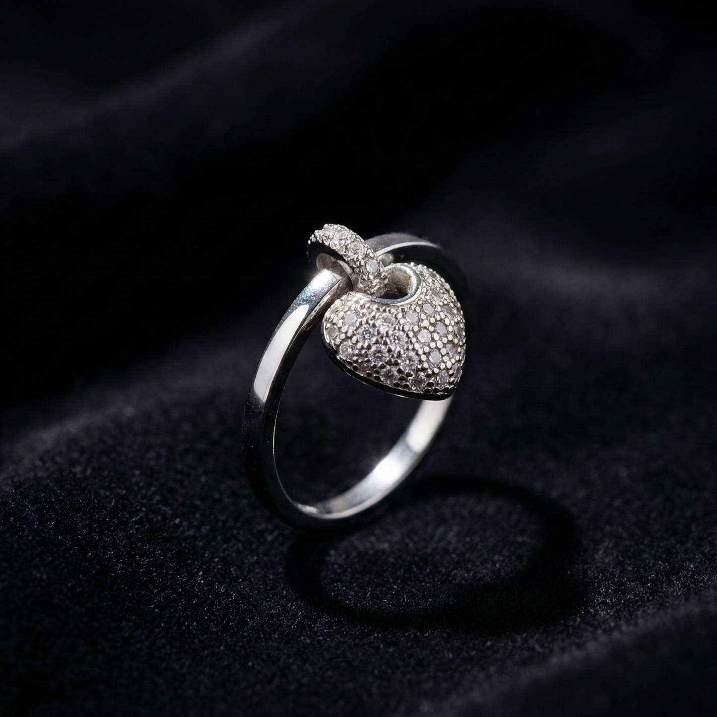 A romantic statement ring defined by a delicate hanging heart silhouette, softly paved with shimmering zircon stones. The Velmora Heart Ring is designed to capture love in motion graceful, expressive, and full of feeling. Its suspended heart detail adds gentle movement, making the design feel alive, emotional, and irresistibly charming.
