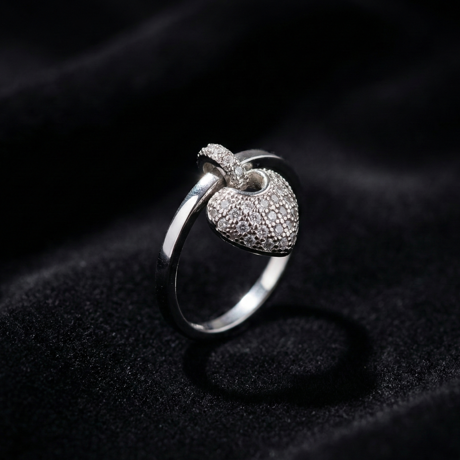 A romantic statement ring defined by a delicate hanging heart silhouette, softly paved with shimmering zircon stones. The Velmora Heart Ring is designed to capture love in motion graceful, expressive, and full of feeling. Its suspended heart detail adds gentle movement, making the design feel alive, emotional, and irresistibly charming.
