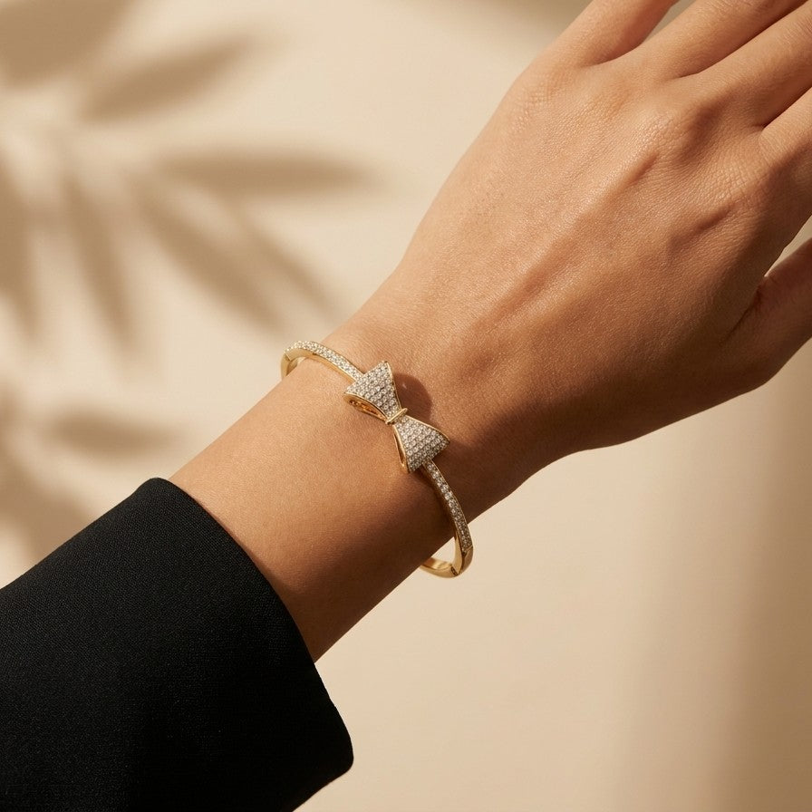 A delicate symbol of elegance and charm, this bow-inspired bracelet captures a soft sparkle that feels both graceful and modern. The sleek curve paired with shimmering stone detailing creates a refined look that effortlessly elevates everyday style.