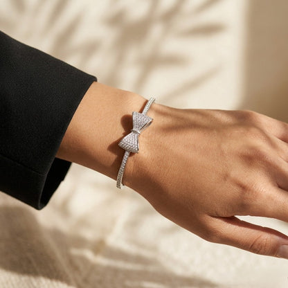 A delicate symbol of elegance and charm, this bow-inspired bracelet captures a soft sparkle that feels both graceful and modern. The sleek curve paired with shimmering stone detailing creates a refined look that effortlessly elevates everyday style.