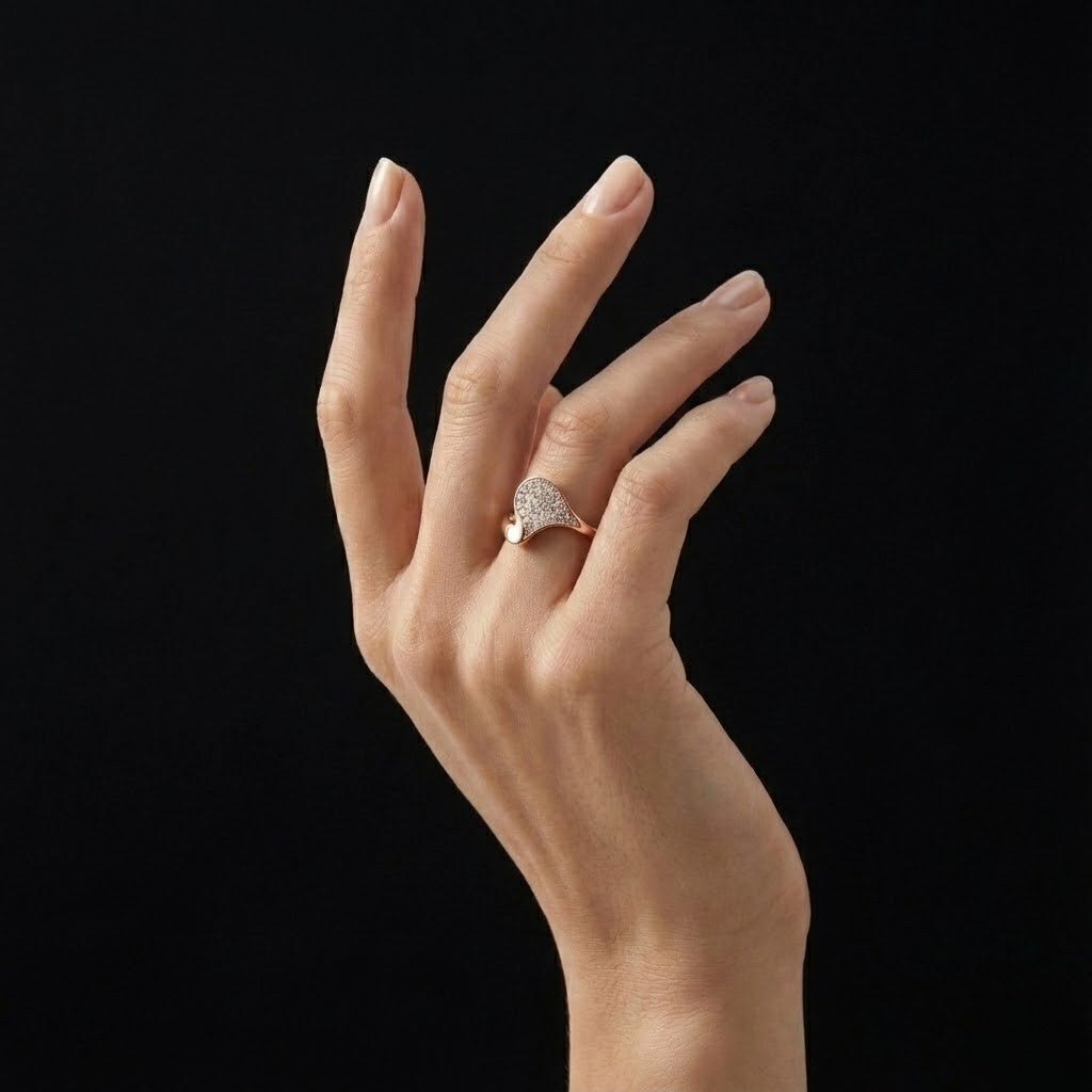 A refined statement ring shaped by gentle curves and subtle brilliance. The Zerelle Curve Ring features a fluid asymmetrical silhouette, accented with delicately set zircon stones that shimmer softly within its sculpted frame. Minimal yet expressive, it’s designed for those who love elegance that feels effortless, modern, and wearable every day.